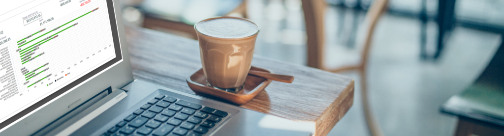 Coffee next to laptop with data
