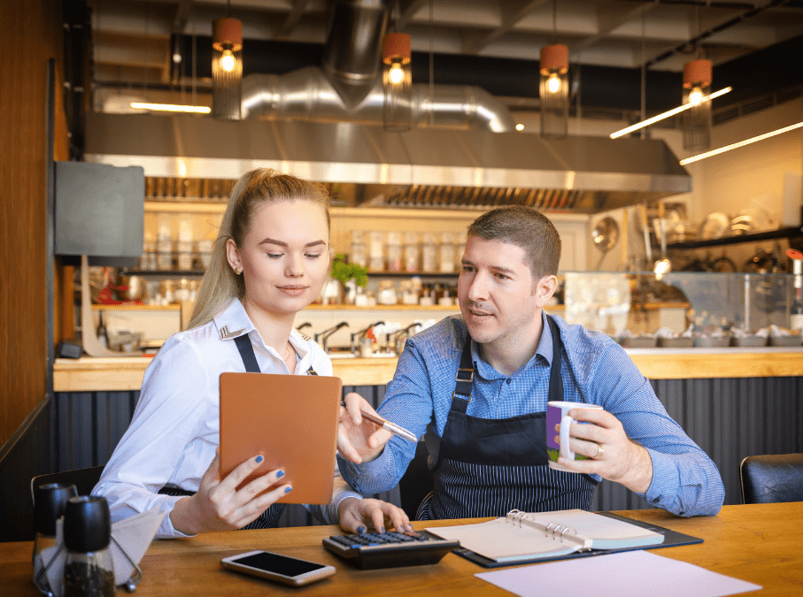 Restaurant employees calculating sales tax in dining room