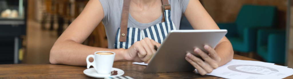 Woman looking at tablet at restaurant table
